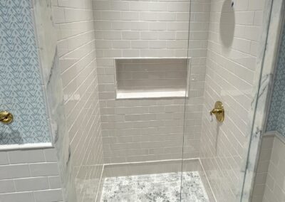 PYRAMID - marble mosaic floor no threshold curbless shower with ceramic subway wainscoting and niche