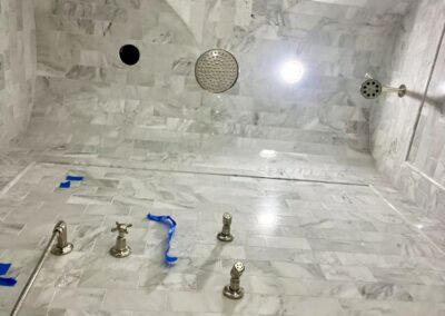 in progress - WINN Design - 3x6 marble in Asian Statuary from TileBar with 5x12 profile base skirting pencil chair rail frame subway with double arch vaulted ceiling with 6x12 Asian Statuary as diagonal herringbone marble on floor