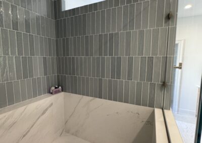 24" x 48" Porcelain Luxe White vertically stacked with Marin 2.5" x 10" Ceramic Misty Blue offset 50% with 0.5" x 12" Jolly Trim